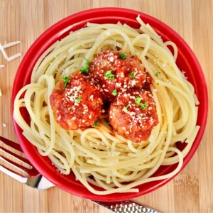 Meatballs with red sauce over noodles.