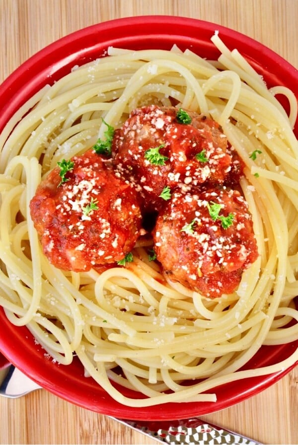 Meatballs with red sauce over noodles.