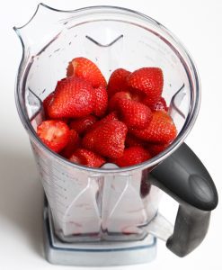 Fresh strawberries in a blender.