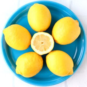 Full lemons around a halved lemon.