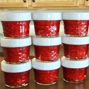 Jars of strawberry jam stacked on each other.