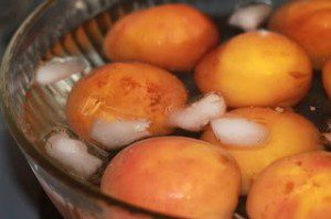 Whole peaches in ice water.