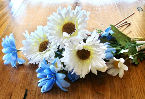Pile of silk flowers on table.