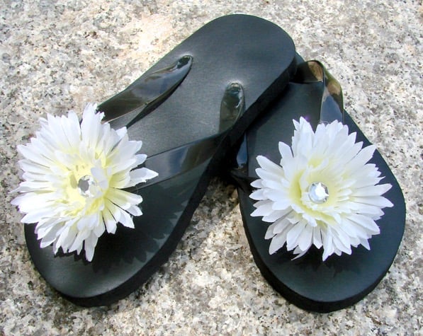 Black flip flops with silk flowers attached.