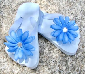 Light blue flip flops with flowers attached.
