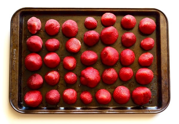 Frozen strawberries on baking sheet.