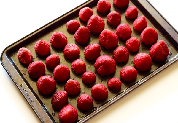 Frozen strawberries on cookie sheet.