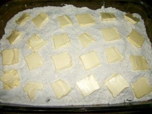 Pats of butter spread over cake mix.