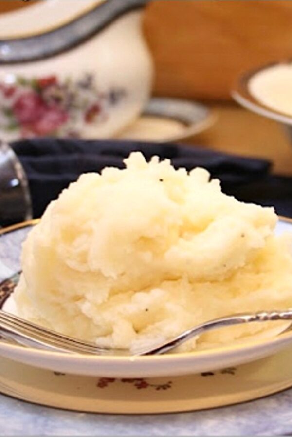 Mashed Potatoes piled on a plate with fork.
