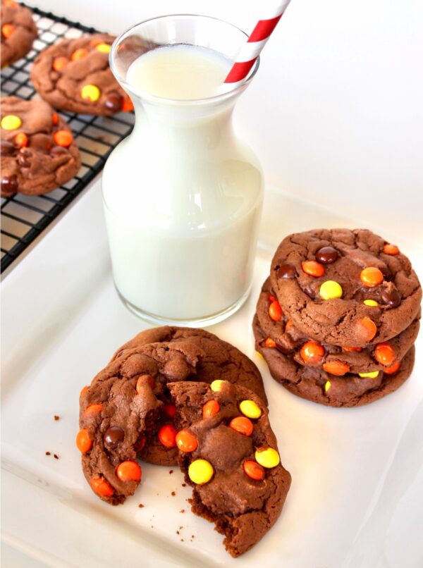 Reese\'s Pieces cookies with milk to the side.