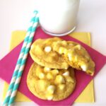 Three lemon cake mix cookies with white chocolate chips on napkin.