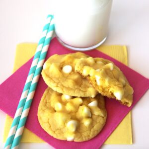 Three lemon cake mix cookies with white chocolate chips on napkin.