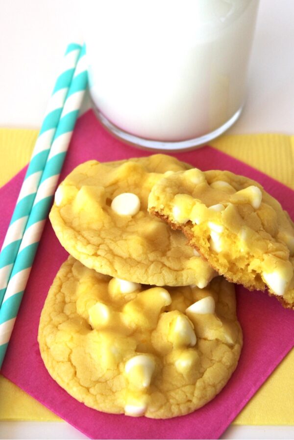 Three lemon cake mix cookies with white chocolate chips on napkin.