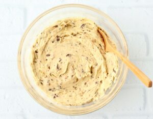 Wooden spoon in a bowl of cookie dough.