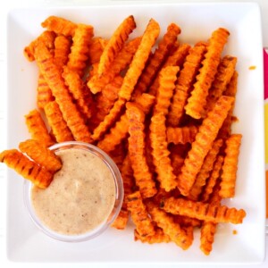 Sweet potato fries on a plate with marshmallow cream dipping sauce.