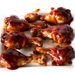 BBQ Drumsticks on a white plate.