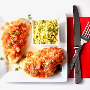 Pineapple Salsa Chicken on a plate with a bowl of rice.