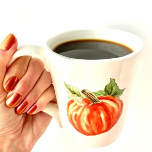 Person holding a mug of Pumpkin Spice Coffee.