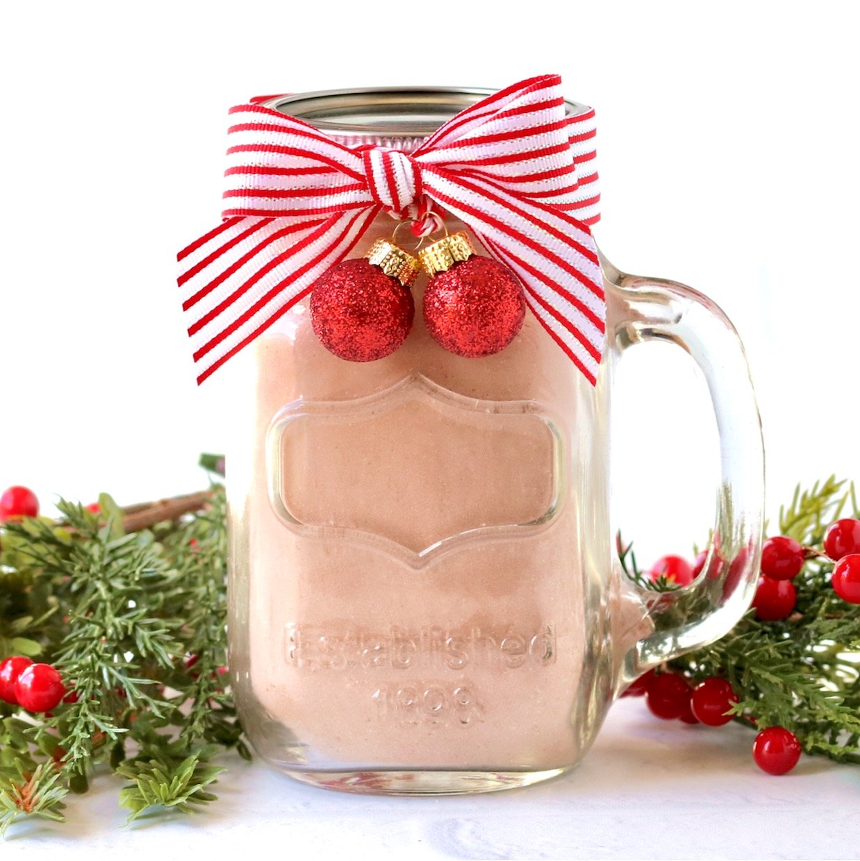 Homemade Hot Chocolate Mix packaged in mason jar mug with lid and bow.