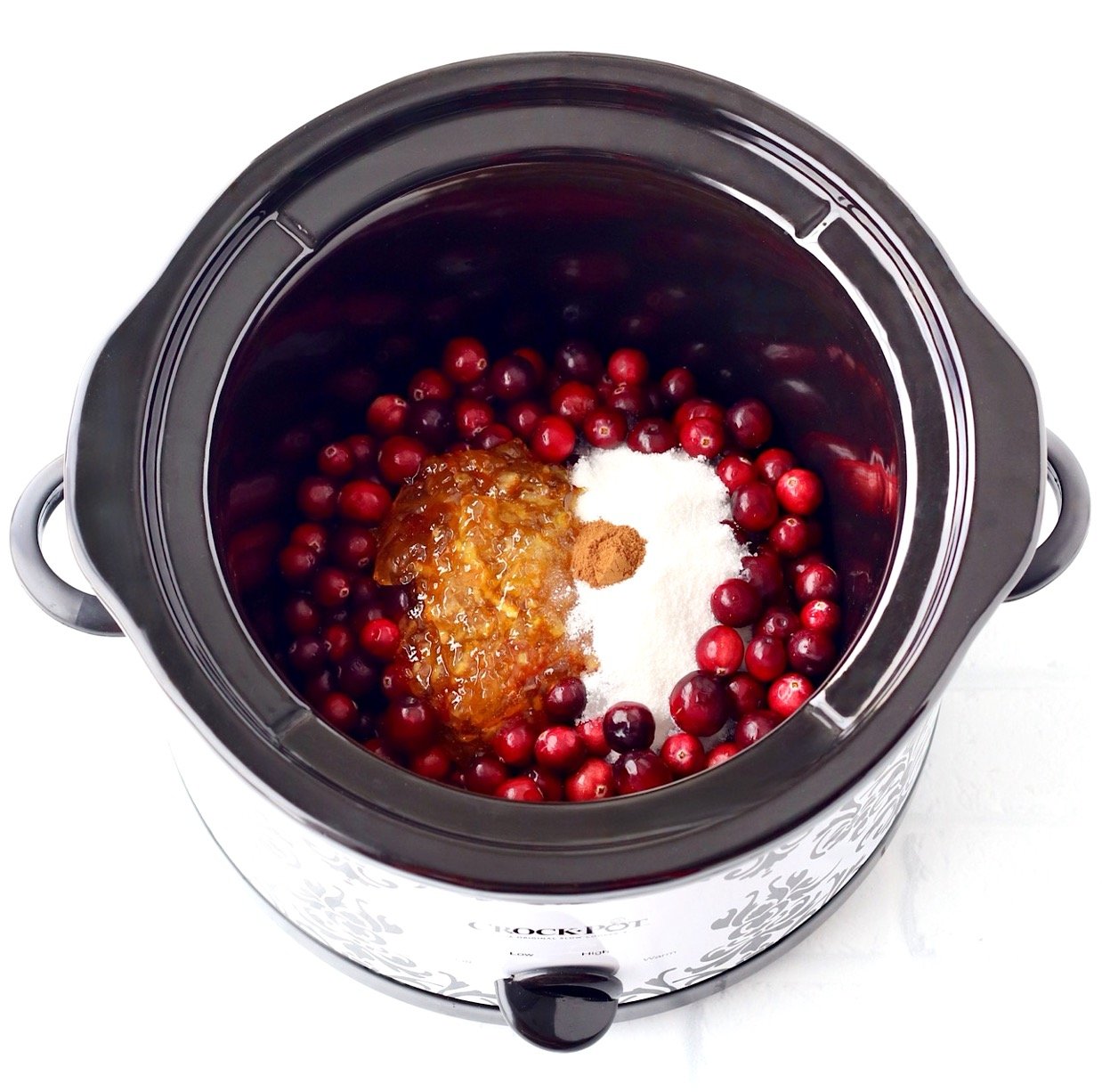 Cranberry sauce ingredients unmixed in crockpot.