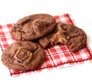 Three chocolate Milky Way cookies on napkin.