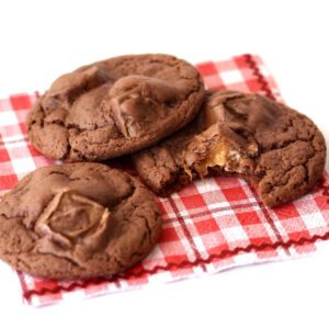 Three chocolate Milky Way cookies on napkin.