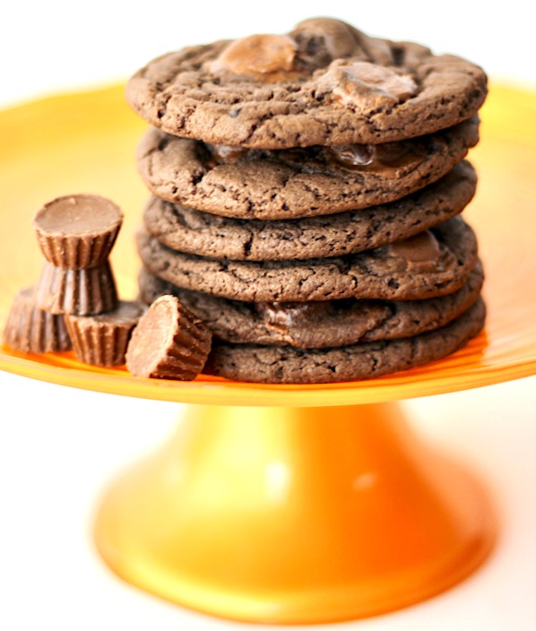 Stack of chocolate Reese's cookies with mini peanut butter cups to the side.