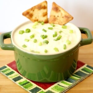 Crab Dip in a green dish with two crackers sticking out.
