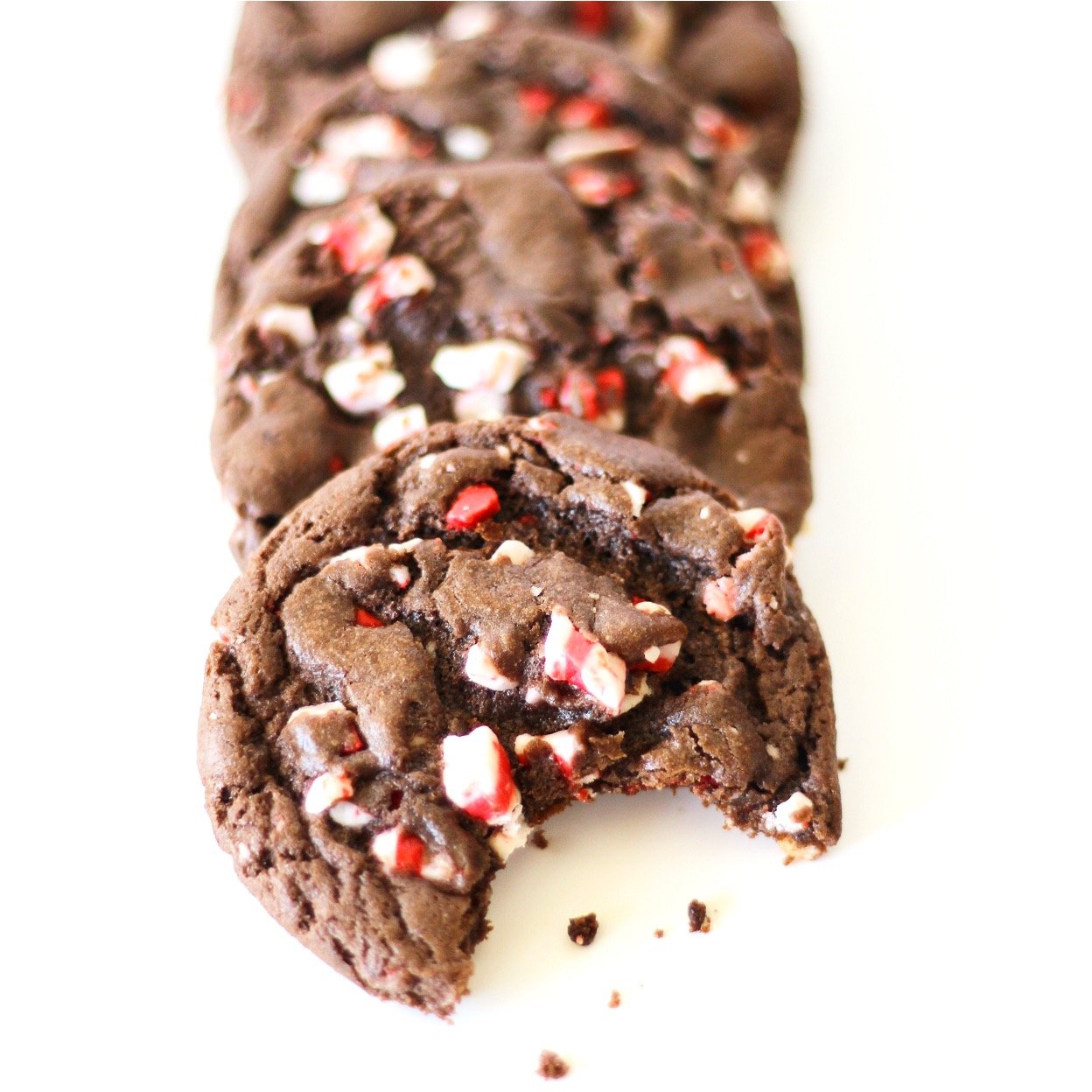 Three chocolate peppermint cookies with bite taken out of one.
