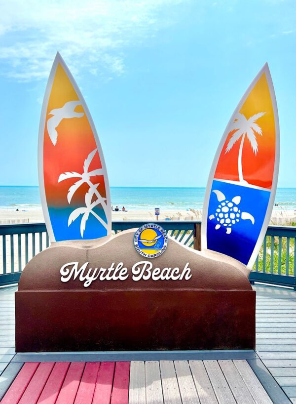 Surf board with a sign that says \"Myrtle Beach.\"
