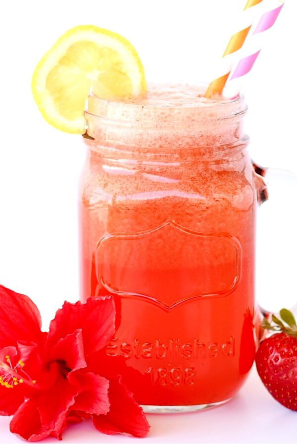 Straw in a jar of strawberry lemonade punch.