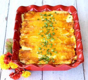 Chicken enchilada casserole in a red baking dish.