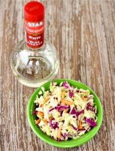 Sweet and Sour Coleslaw with a bottle of white wine vinegar.