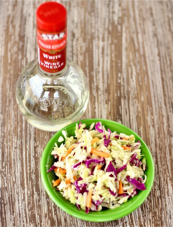 Sweet and Sour Coleslaw with a bottle of white wine vinegar.