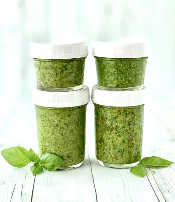Four mason jars filled with pesto.