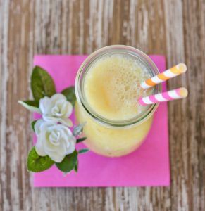 Flowers with a glass of copycat orange Julius.