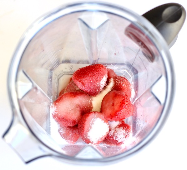 Strawberries and other ingredients in a blender.