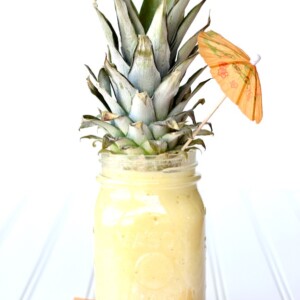 Tropical Pineapple Smoothie in a jar topped with a pineapple top.