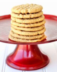 Peanut Butter Cookies stacked on a red plate.
