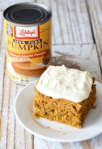 Slice of pumpkin spice cake topped with frosting.