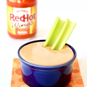 Buffalo Ranch Dipping Sauce in a blue dish with two slices of celery sticking out.