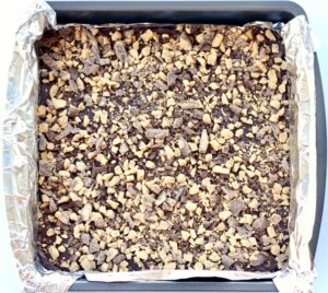 Heath toffee fudge in a foil-lined baking dish.