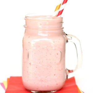 Strawberry Banana Protein Smoothie in a jar with straws.