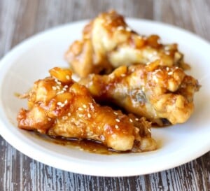 Cooked chicken wings on plate with teriyaki sauce.