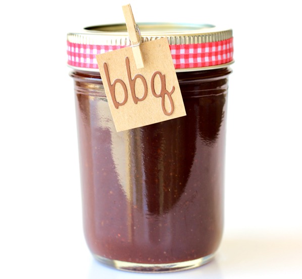 Barbecue sauce in mason jar with ribbon around lid and bbq label.