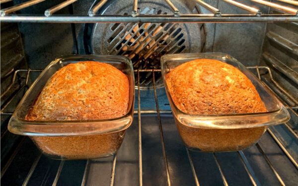 Two loafs of banana bread in an oven.