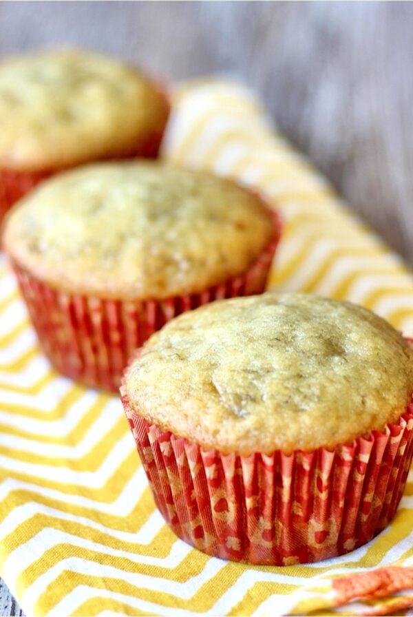Three banana bread muffins on napkin.