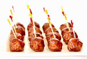 Plate of barbecue meatballs with toothpicks.