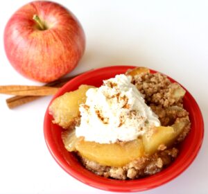 Baked apple dump cake with whipped cream on top.
