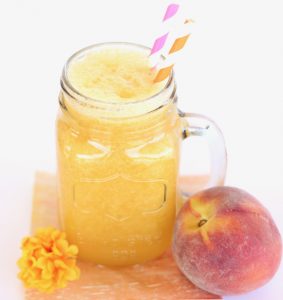 Jar of peach punch with straws.